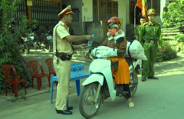 Cảnh sát giao thông Công an huyện Trạm Tấu phát nước miễn phí cho người dân.