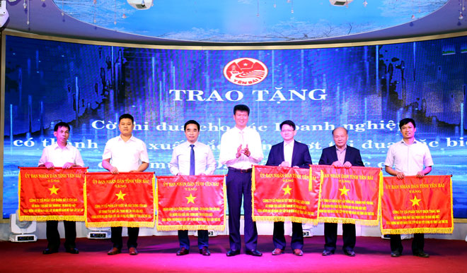 Chairman of the Yen Bai provincial People’s Committee Tran Huy Tuan presents emulation flags to six collectives in recognition of their outstanding achievements in the special emulation campaign held to mark the 19th provincial Party Congress this year.