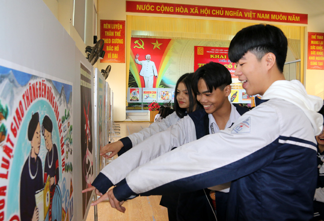 Các em học sinh Trường THPT Chuyên Nguyễn Tất Thành xem tranh cổ động tại Triển lãm.