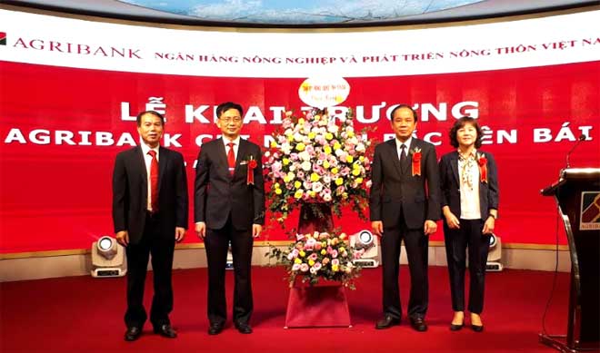 Đồng chí Tạ Văn Long tặng hoa chúc mừng sự ra đời của Ngân hàng Agribank Bắc Yên Bái.
