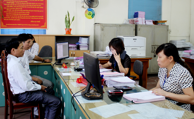 Cán bộ Chi cục Thuế huyện Trấn Yên giải quyết các thủ tục hành chính với người nộp thuế. 