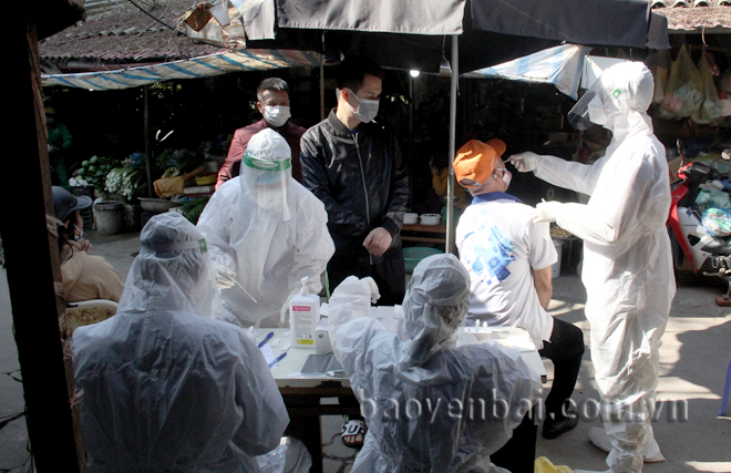 Lực lượng y tế lấy mẫu xét nghiệm Covid-19 cho các tiểu thương tại chợ Yên Thịnh, thành phố Yên Bái. Ảnh: Thu Trang 