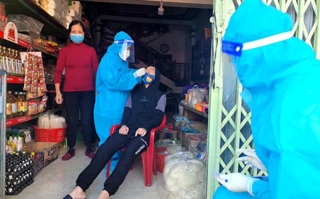 Cán bộ y tế huyện Yên Bình lấy mẫu xét nghiệm diện rộng trên địa bàn thị trấn huyện Yên Bình. (Ảnh: Minh Huyền)
