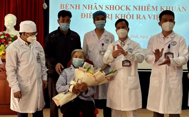 Các y, bác sỹ Trung tâm Y tế Yên Bình tặng hoa chúc mừng bệnh nhân Hoàng Thị Duyên.