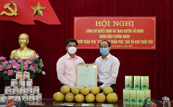 Lãnh đạo Sở Khoa học và Công nghệ trao Giấy chứng nhận nhãn hiệu 3 sản phẩm cho UBND huyện Trấn Yên.
