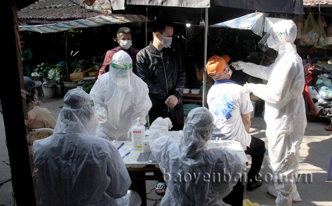 Lực lượng y tế lấy mẫu xét nghiệm Covid-19 cho các tiểu thương tại chợ Yên Thịnh, thành phố Yên Bái. Ảnh: Thu Trang
