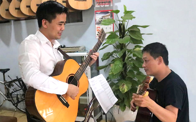 Giảng viên, nhạc sĩ Bùi Quốc Huy hướng dẫn học trò chơi đàn guitar.