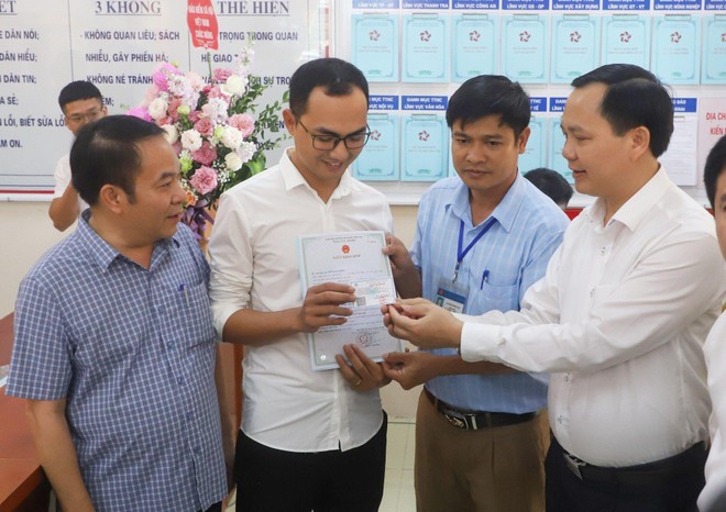 Phó Tổng Giám đốc BHXH Việt Nam Chu Mạnh Sinh trao thẻ BHYT của bé gái cho anh Đinh Tiến Hoàng