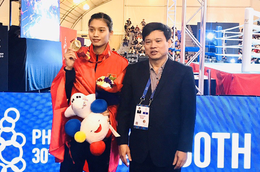 Phó Chủ tịch UBND thành phố Hà Nội Ngô Văn Quý (phải) chia vui với võ sĩ Nguyễn Thị Tâm.