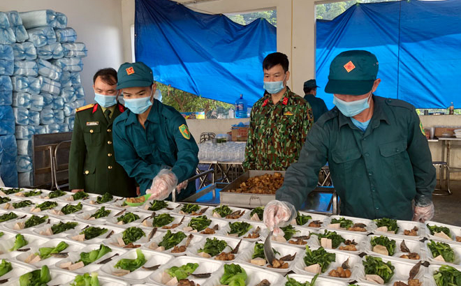 Các chiến sĩ dân quân tự vệ chuẩn bị bữa ăn hàng ngày cho công dân trong Khu cách ly số 6 tại Trung tâm Huấn luyện và bồi dưỡng nghiệp vụ Công an tỉnh. Ảnh: Thanh Chi