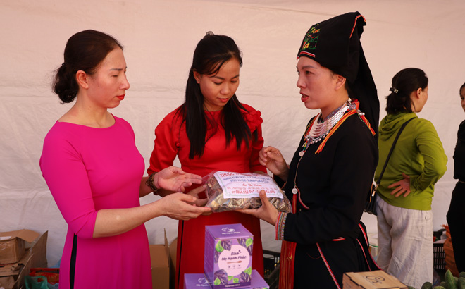 Chị Mai Thị Thông (bên phải) giới thiệu sản phẩm thuốc nam của người Dao với khách hàng.