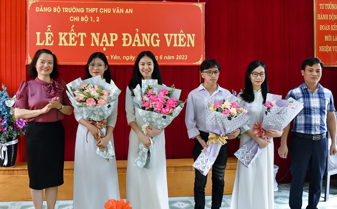 Các đồng chí lãnh đạo huyện Văn Yên tặng hoa chúc mừng các đảng viên mới là học sinh của Đảng bộ Trường THPT Chu Văn An, Văn Yên