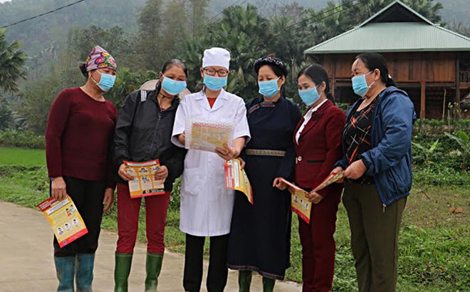 Cán bộ Trạm Y tế xã Việt Hồng, huyện Trấn Yên hướng dẫn người dân các biện pháp phòng dịch COVID-19 tháng 3/2020. (Ảnh: Minh Huyền)