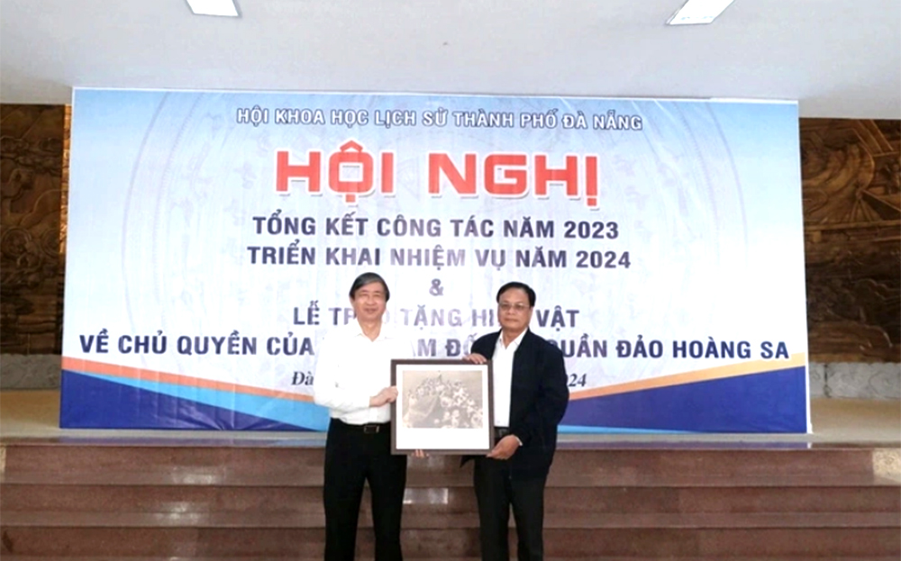 Ông Bùi Văn Tiếng - Chủ tịch Hội Khoa học lịch sử Đà Nẵng (bên trái), trao tặng bức ảnh là tư liệu quý về Hoàng Sa cho ông Võ Ngọc Đồng - Chủ tịch UBND huyện Hoàng Sa.