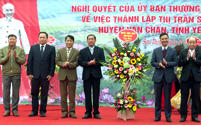 Đồng chí Dương Văn Tiến - Phó Chủ tịch UBND tỉnh tặng hoa chúc mừng Đảng bộ, chính quyền, nhân dân thị trấn Sơn Thịnh.