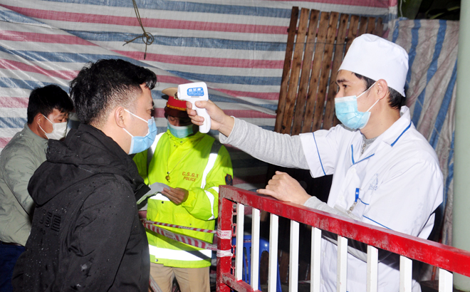 Các y, bác sĩ đo thân nhiệt cho người dân tại chốt kiểm dịch vào địa bàn tỉnh Yên Bái.