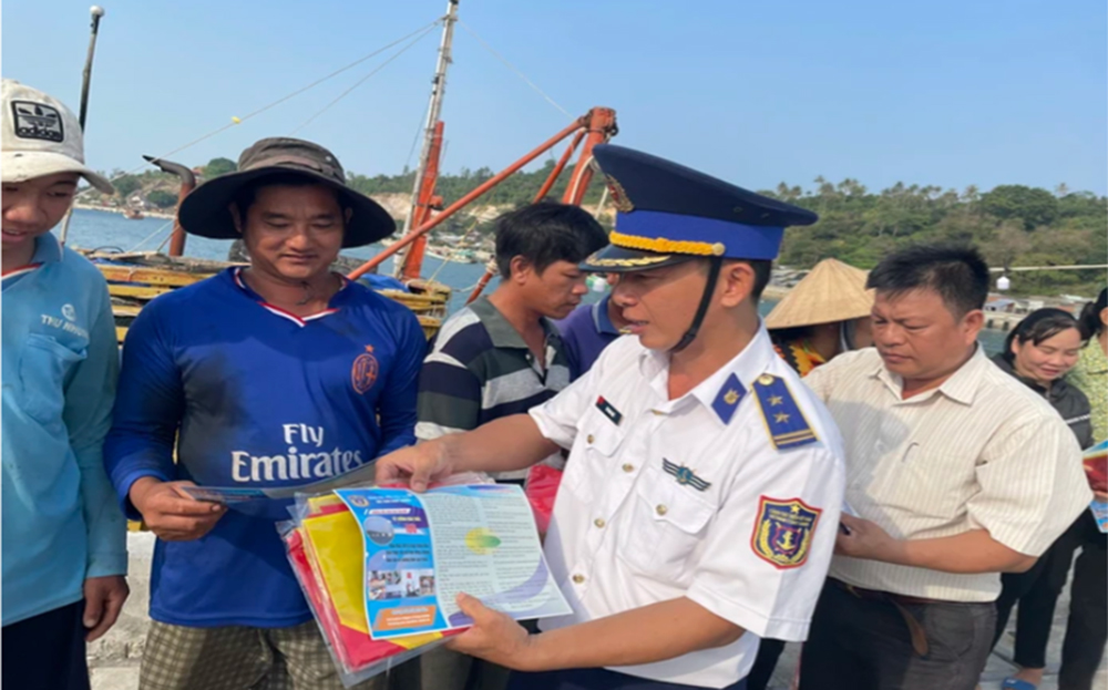 Tuyên truyền viên của Bộ Tư lệnh Vùng Cảnh sát biển 4 tuyên truyền, phát tờ rơi cho ngư dân tại cảng cá.