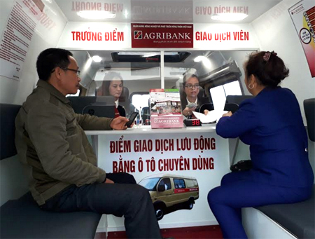 Giao dịch lưu động trên xe ô tô, mang dịch vụ tín dụng của Agribank Chi nhánh Yên Bái đến vùng sâu, vùng xa của tỉnh. (Ảnh: Lê Phiên)