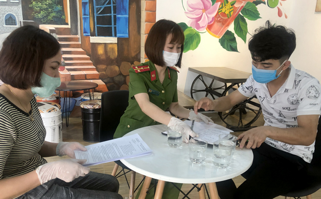 Lực lượng chức năng phường Đồng Tâm, thành phố Yên Bái tuyên truyền, giúp các hộ kinh doanh dịch vụ ký cam kết tạm dừng  hoạt động từ hôm nay-28/3 để phòng, chống dịch COVID-19