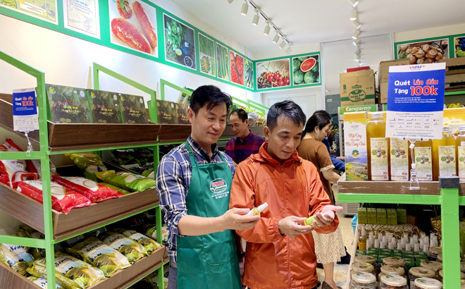 Anh Hà Văn Minh - chủ cửa hàng (người bên trái) giới thiệu các sản phẩm OCOP của Yên Bái tại AnnMart