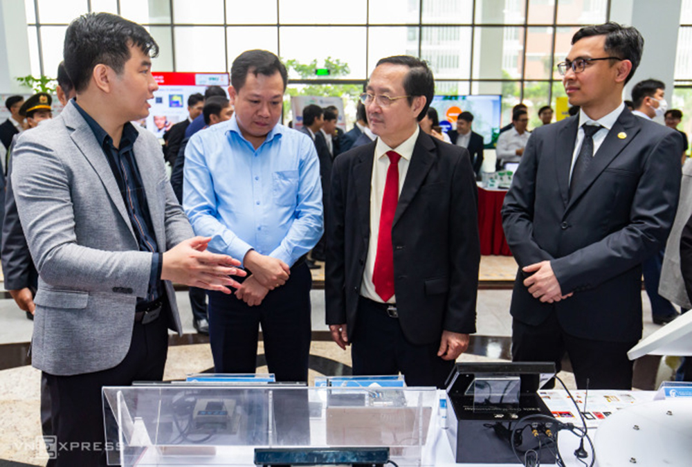 Bộ trưởng Huỳnh Thành Đạt (thứ ba từ trái sang) tham quan triển lãm Công nghệ chip bán dẫn với hàng chục gian hàng giới thiệu công trình nghiên cứu, mô hình sản phẩm có tính ứng dụng cao tại Đại học Quốc gia Hà Nội hồi tháng 4/2023.