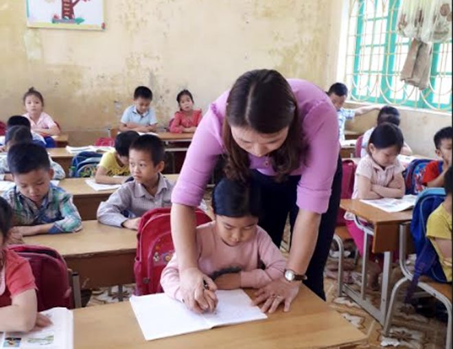 Cô giáo Đàm Thị Thanh Nga uốn nắn từng nét chữ cho học sinh.