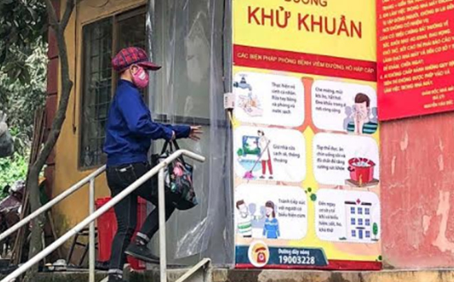 Workers of Yen Bai Cement and Minerals joint Stock Company go through a disinfection cabin before entering the workplace