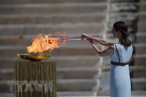 Diễn viên Hy Lạp Xanthi Georgiou trong trang phục nữ tư tế tối cao thắp ngọn đuốc Olympic trong lễ trao đuốc cho Nhật Bản tại Athens, Hy Lạp, ngày 19/3/2020.