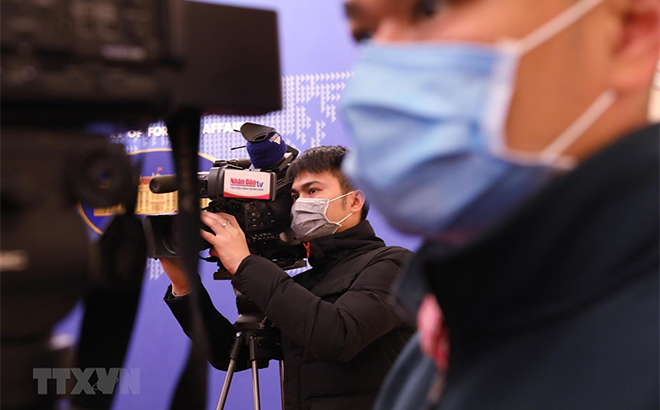 Phóng viên các cơ quan báo chí đeo khẩu trang tác nghiệp tại họp báo.