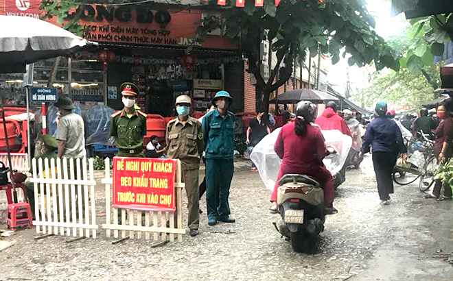 Các lực lượng chức năng giám sát việc người dân tuân thủ các quy định về phòng, chống dịch bệnh Covid-19 tại cổng chợ Yên Ninh (thành phố Yên Bái).