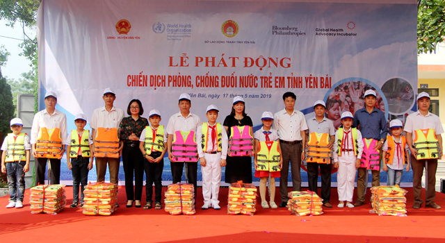 Đại diện lãnh đạo Sở Lao động, Thương binh và Xã hội, lãnh đạo UBND huyện Văn Yên tặng áo phao cho 6 trường tiểu học.