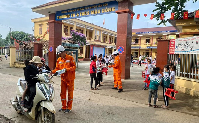 Công nhân Công ty điện lực chi nhánh huyện Văn Yên phát tờ rơi cho phụ huynh và học sinh Trường TH&THCS Mậu Đông tuyên truyền về nguy cơ, hiểm họa gây mất an toàn trong việc sử dụng điện và nguy cơ cháy nổ, gây mất an toàn cho hệ thống lưới truyền tải điện.