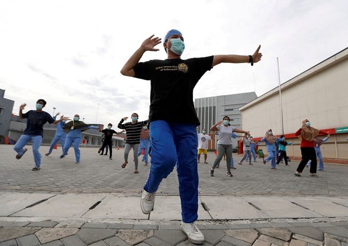 Các bác sỹ, y tá, người tình nguyện tham gia tập thể dục cùng các bệnh nhân ở một khu cách ly ở Indonesia.