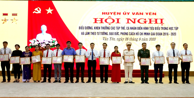 Chairman of the People’s Committee of Van Yen district Ha Duc Anh presents certificates of merits to collectives and individuals with outstanding performance in studying and following President Ho Chi Minh’s lifestyle and moral example in the 2016-2020 period.
