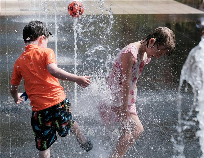 Trẻ em chơi dưới đài phun nước nhằm làm dịu nắng nóng ở Nice, miền Nam Pháp ngày 17/6/2022.