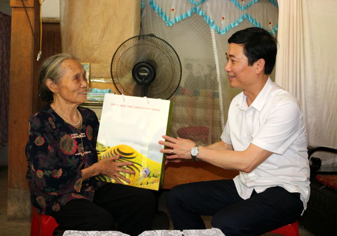 Đồng chí Trưởng ban Tuyên giáo Tỉnh ủy Nguyễn Minh Tuấn thăm và tặng quà bà Lương Thị Len, là thân nhân liệt sỹ ở thị trấn Trạm Tấu.