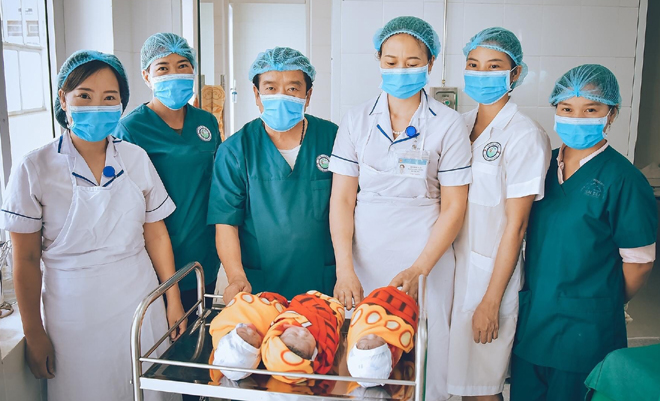 Các y, bác sĩ Trung tâm Y tế huyện Mù Cang Chải chia sẻ niềm vui bên ba bé gái vừa chào đời trong ca mổ sinh 3.