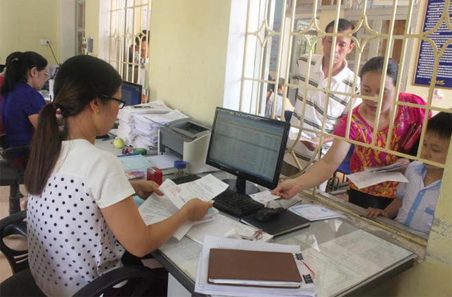 Cán bộ giám định của BHXH huyện Yên Bình kiểm tra thủ tục hành chính KCB BHYT, trước khi người bệnh lĩnh thuốc tại Trung tâm Y tế huyện Yên Bình.