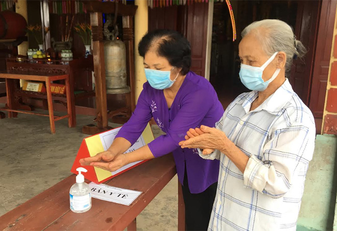 Người dân đến chiêm bái, thực hành tín ngưỡng tại chùa Linh Long, phường Yên Ninh, thành phố Yên Bái thực hiện tốt quy định đeo khẩu trang và rửa tay sát khuẩn.
