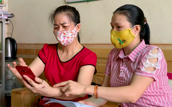 Hội Phụ nữ phường Minh Tân, thành phố Yên Bái hướng dẫn người dân cài đặt ứng dụng Bluezone trên điện thoại thông minh.