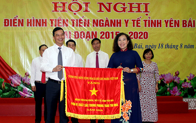 Thừa ủy quyền, Phó Chủ tịch UBND tỉnh Dương Văn Tiến trao Cờ thi đua của Thủ tướng Chính phủ cho Bệnh viện Đa khoa tỉnh Yên Bái.