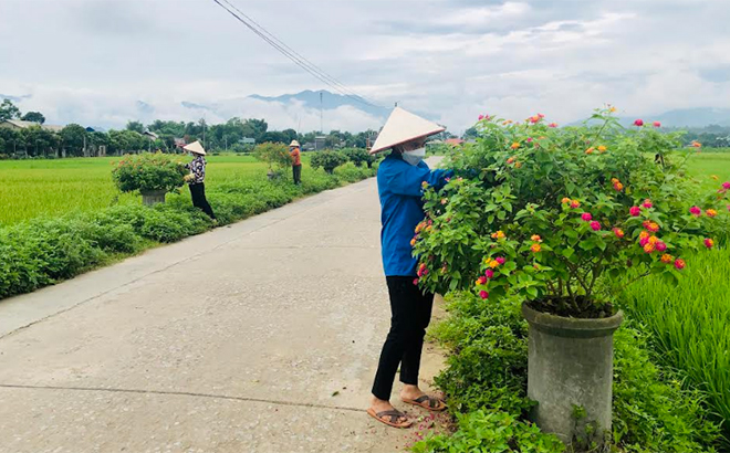 Local residents in Son A commune take care of flowers along the lighted, green, clean and beautiful road in the locality.
