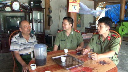Đại úy Triệu Anh Tuấn (ngồi giữa) luôn bám sát cơ sở để vận động nhân dân tham gia Phong trào “Toàn dân bảo vệ an ninh Tổ quốc”.