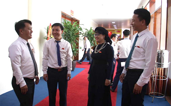 Đại biểu Triệu Văn Huấn và Phan Thị Trung Kiên (đứng giữa) - Đoàn đại biểu Đảng bộ huyện Lục Yên trao đổi với các đại biểu về dự Đại hội.