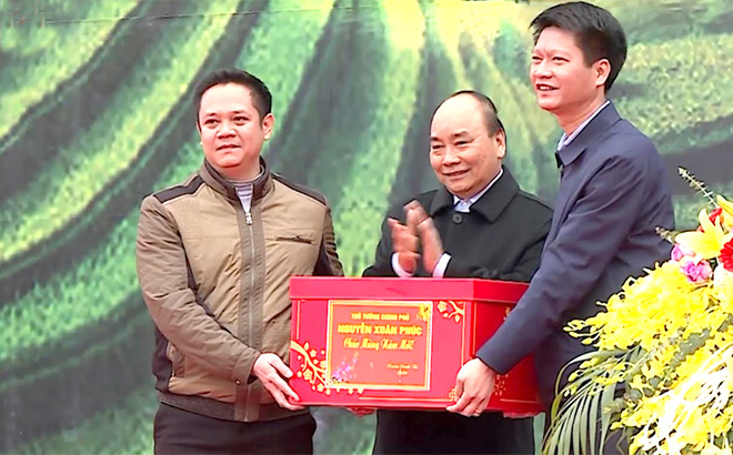 Thủ tướng Chính phủ Nguyễn Xuân Phúc tặng quà huyện Trấn Yên - huyện đầu tiên đạt chuẩn nông thôn mới khu vực Tây Bắc. (Ảnh: Hoài Văn)