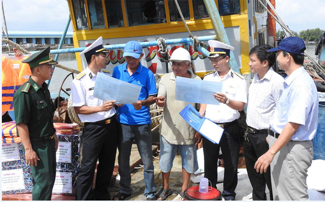 Cán bộ Vùng 2 Hải quân phát tờ rơi tuyên truyền Chỉ thị 45 của Thủ tướng Chính phủ cho ngư dân.
